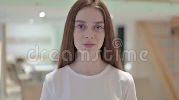 雄心勃勃的红头发年轻女子竖起大拇指的肖像视频的预览图