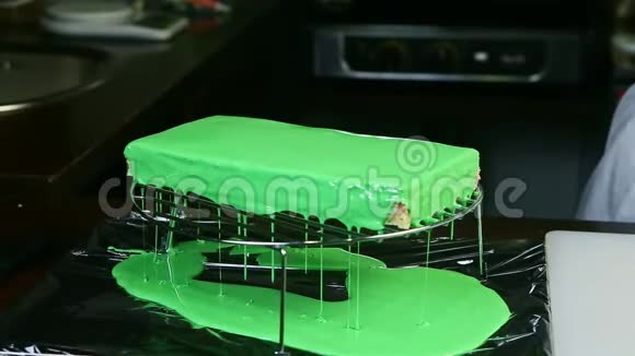 绿色糖霜从带有奶油和水果夹层的长方形蛋糕上流下来视频的预览图