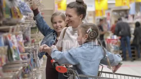 年轻有魅力的妈妈和孩子们在超市买食物的肖像幸福家庭选择的视角视频的预览图