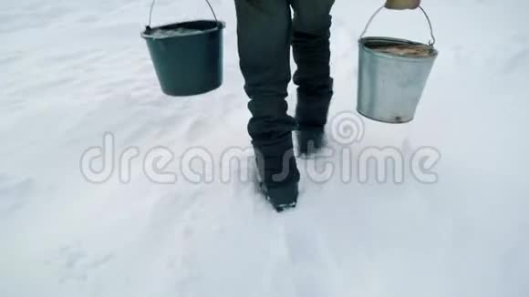 一个冬天有水桶的老人从井里提水手持射击视频的预览图