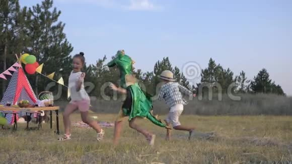 有趣的孩子们穿着狂欢节服装的小女孩和她的朋友们一起在森林玩游戏捉到他们并追着他们跑视频的预览图