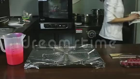 厨师制服的糖果师从特殊的白色蛋糕中取出一个冷冻椭圆形蛋糕视频的预览图