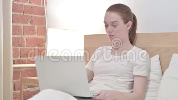 快乐的红头发青年妇女在电脑上做视频聊天视频的预览图