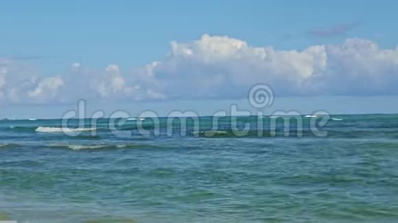 在蔚蓝的海洋上飘浮着巨大的白云带着强烈的白色波浪缓慢的全景视频的预览图