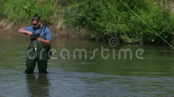 一个渔夫拿着一根鱼竿在一个小袋子里找鱼饵视频的预览图