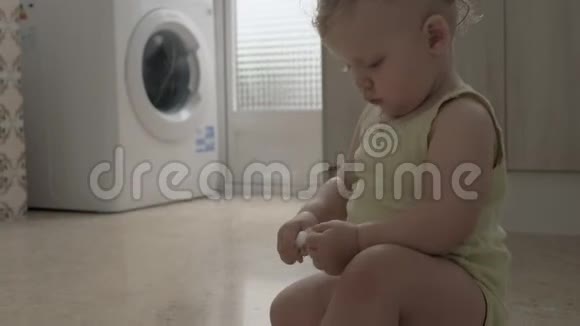 快乐活泼的女婴在家里的厨房里爬行和玩耍视频的预览图