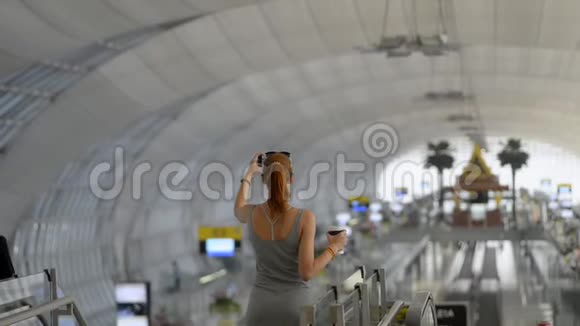 年轻的美国女旅行者在机场拍摄内部站立的照片视频的预览图