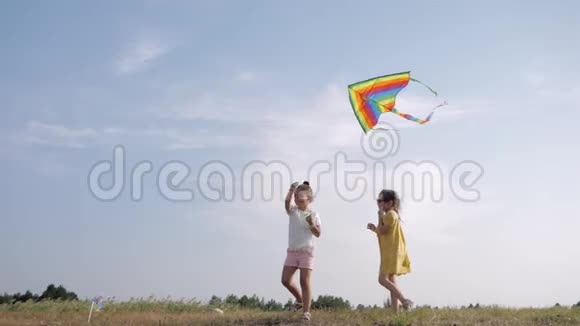 夏日放松快乐的小女朋友周末在蓝天的背景下在户外玩风筝视频的预览图
