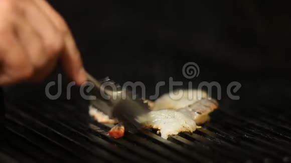 厨师把烟熏虾倒在烤架上快关门视频的预览图