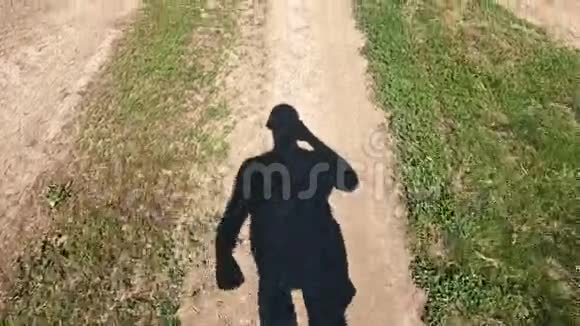 走在乡间小路上的人的影子视频的预览图