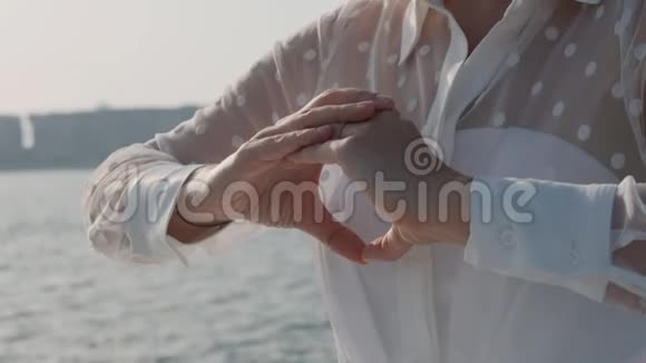 在阳光明媚的一天女人在海边冥想做瑜伽慢动作特写视频的预览图
