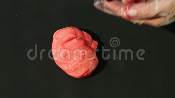 上景特写女性双手将红色着色剂加入到粉红色杏仁核中揉捏视频的预览图