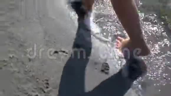 在浅滩散步赤脚男子度假者沿着海滩和海浪冲洗他的脚的俯视图视频的预览图