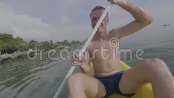 夏天在热带小岛上微笑的年轻人在海上划皮艇很开心视频的预览图