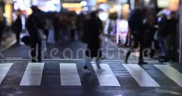 在新宿东京的十字路口行走的人夜间雨天视频的预览图