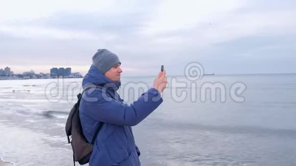 在沿海城市附近的冬天在海上行走的人在打电话视频的预览图