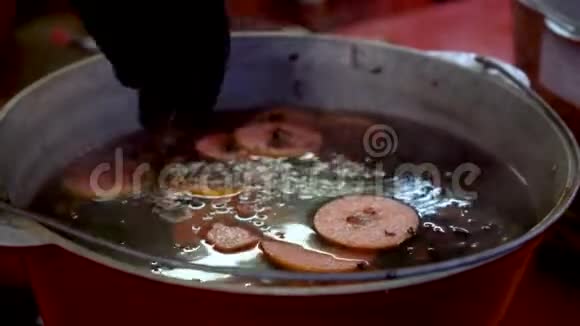 圣诞节市场上的大锅里的冲子和覆盖葡萄酒的配料柑橘和香料的成分视频的预览图