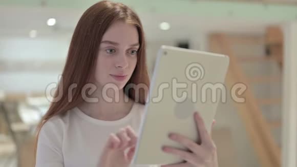 红发青年妇女用平板电脑肖像画视频的预览图