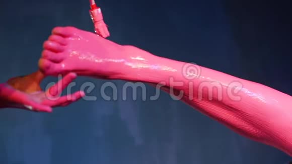 特写艺术家用粉红色的颜料画出模型腿视频的预览图