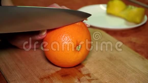 木板上的女孩用刀切开一个成熟多汁的维他命红葡萄柚视频的预览图