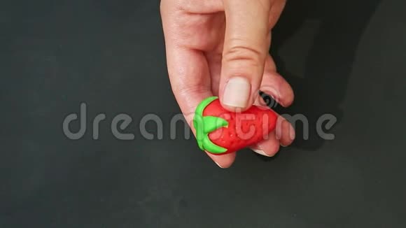 上景特写女人手做红色草莓形状的杏仁糖视频的预览图