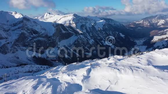 在瑞士阿尔卑斯山的雪山上空飞行在冬天白天视频的预览图