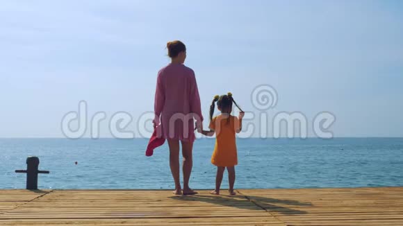 母女俩沿着海边的码头漫步欣赏大海视频的预览图
