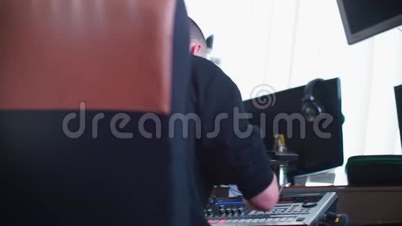 作曲家在录音室的调音台上演奏音乐视频的预览图
