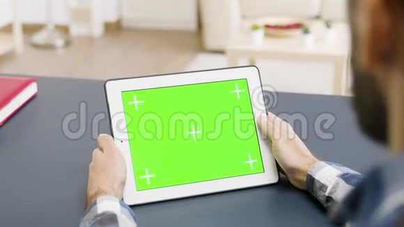 肩膀上有人拿着绿色屏幕的平板电脑视频的预览图