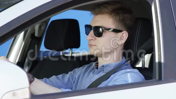 穿着休闲装和太阳镜的布鲁内特男子正在驾驶绿色屏幕背景的汽车他笑着坐在他的椅子上视频的预览图