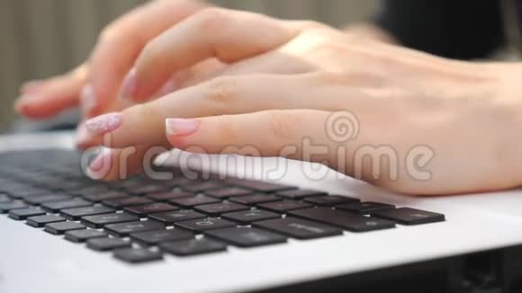 女性手指在笔记本键盘上输入一些文字无法辨认的女人在户外使用笔记本电脑女孩在聊天视频的预览图