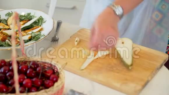 一只雌性手把一个梨切成薄片然后放入沙拉烹制美味健康的早餐视频的预览图