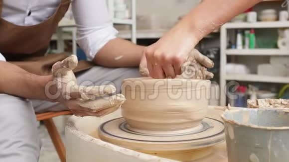 制作米色粘土特写花瓶作坊里的雕刻家用粘土做罐子扭曲的锅轮子视频的预览图