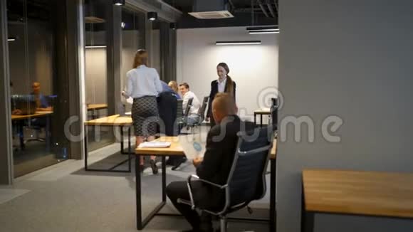 年轻的混血儿在深夜的办公桌上谈论和使用笔记本电脑和画画的商务人士视频的预览图