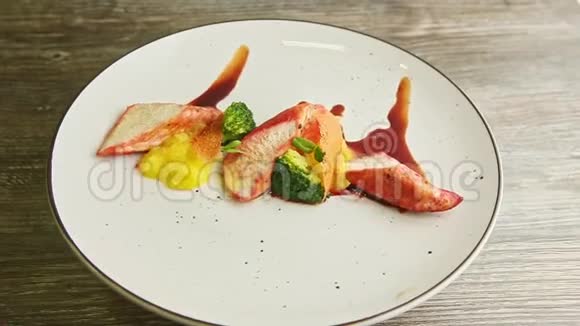 装饰精美的烤鸡和西兰花片在盘子上旋转视频的预览图