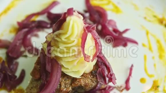 用土豆泥和红洋葱在肉片上特写全景视频的预览图