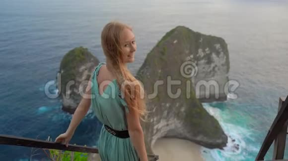 年轻女子游客参观了所谓的暴龙岩在克林金海滩努沙佩尼达印度尼西亚著名的视频的预览图