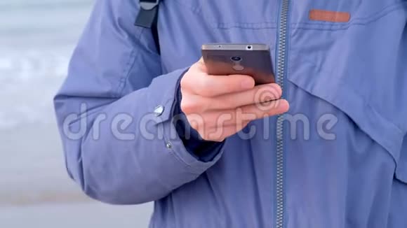冬天在海滨小镇上人们在智能手机上输入信息手忙脚乱视频的预览图