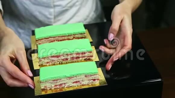糖果师将三份奶油分层蛋糕与绿色釉视频的预览图