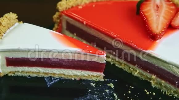 从一半到一块带有草莓果冻的釉面芝士蛋糕的特写全景视频的预览图