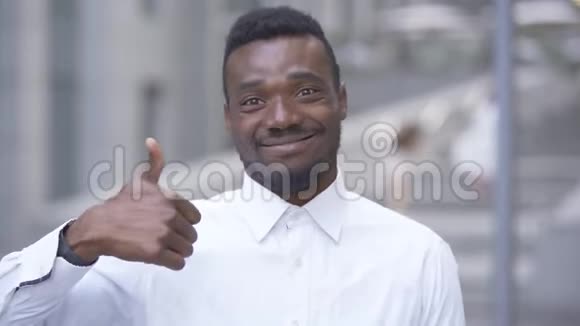 一位身穿白色衬衫的美国黑人男子用拇指向上看着摄像机男商人或经理视频的预览图