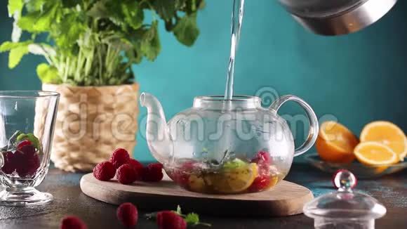 用草本植物和覆盆子视频高清在玻璃茶壶中倒入热水的过程视频的预览图