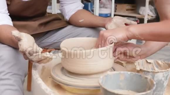 制作米色粘土特写花瓶作坊里的雕刻家用粘土做罐子扭曲的锅轮子视频的预览图