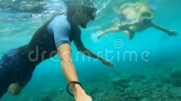 父亲和儿子在印度尼西亚NusaPenida岛的水晶湾海滩上在清澈的蓝色水中浮潜视频的预览图