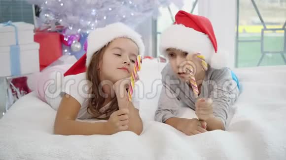 温暖的圣诞节气氛在这种气氛中快乐的姐姐和哥哥玩糖果棒模仿剑战姐姐视频的预览图