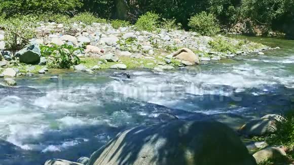 宽阔的山河水流大石急流阳光明媚视频的预览图