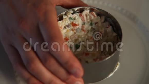 做俄罗斯沙拉厨师用肉鹌鹑蛋泡菜和草药装饰俄罗斯沙拉特写镜头视频的预览图