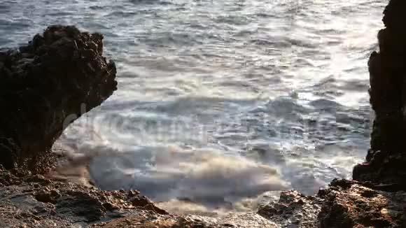 海波在希腊角的阿伊亚安阿尔吉罗伊洞穴岩石上断裂视频的预览图