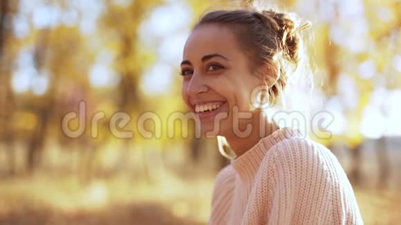 奥坦森林里穿着针织粉色毛衣的漂亮年轻笑女的特写视频的预览图