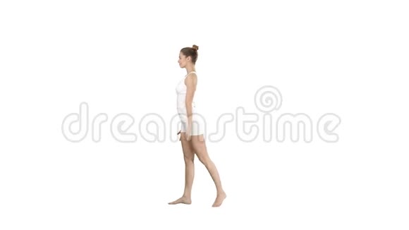 运动的年轻女性练习瑜伽站在UtthitaTrikonasana的白色背景上视频的预览图